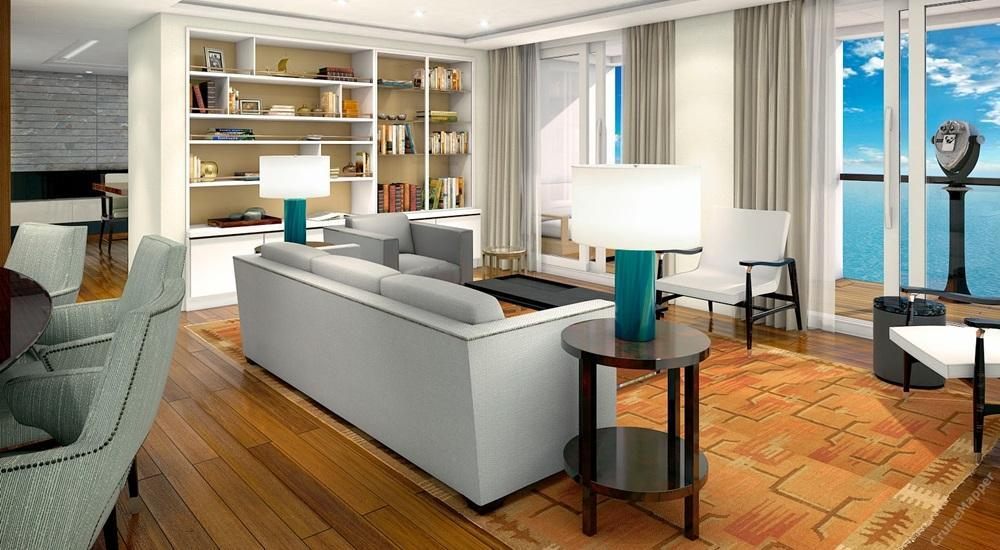 A large suite living room with bookshelves, sofas and a chess table by the windows